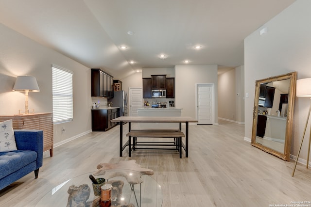 kitchen with dark brown cabinets, light wood-type flooring, appliances with stainless steel finishes, and vaulted ceiling