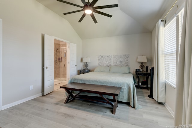 bedroom with ensuite bathroom, ceiling fan, multiple windows, and vaulted ceiling