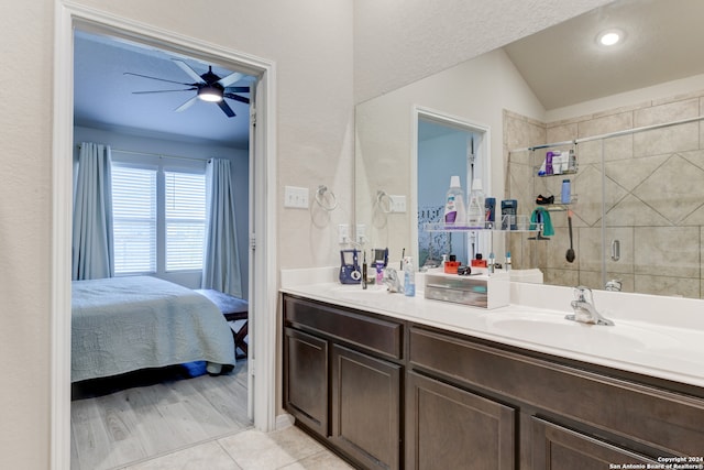 bathroom with an enclosed shower, vanity, vaulted ceiling, ceiling fan, and hardwood / wood-style floors