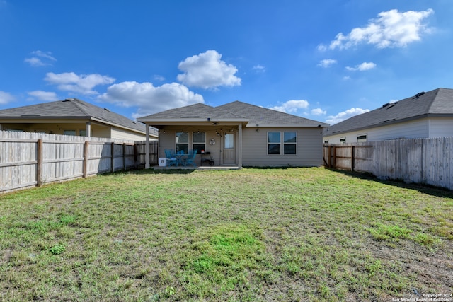 rear view of property featuring a yard, a patio, and ceiling fan