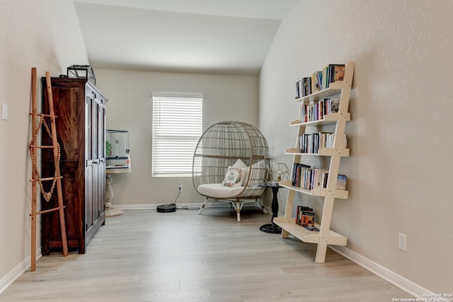 living area featuring lofted ceiling and light wood-type flooring