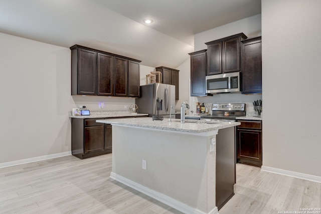 kitchen featuring dark brown cabinets, light hardwood / wood-style floors, stainless steel appliances, and an island with sink