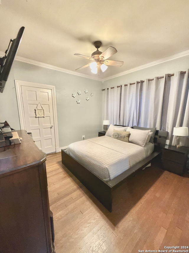 bedroom featuring light hardwood / wood-style flooring, ceiling fan, and ornamental molding