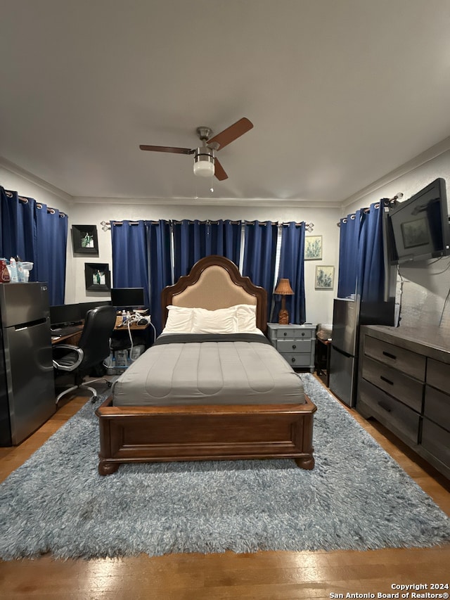 bedroom with ceiling fan, stainless steel fridge, wood-type flooring, and crown molding