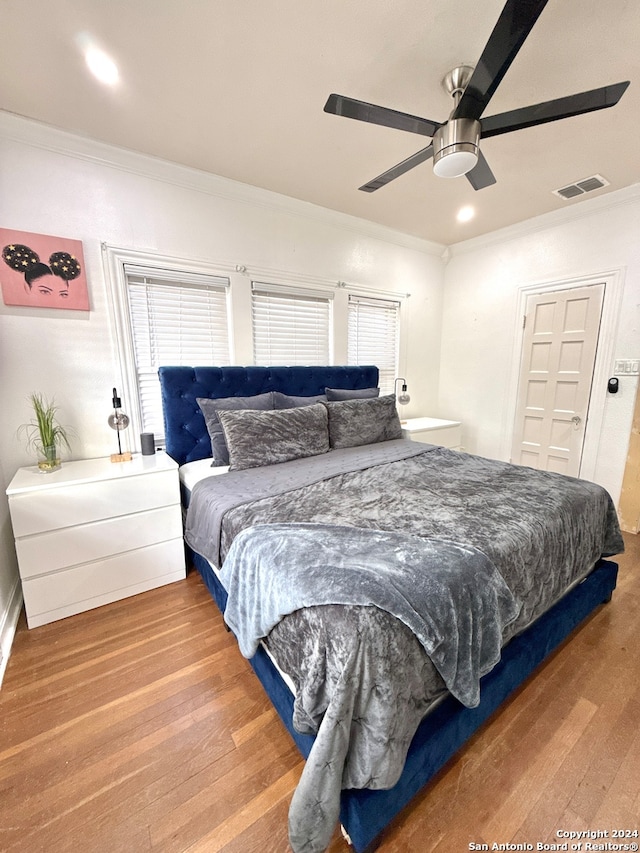 bedroom with ceiling fan, crown molding, and wood-type flooring