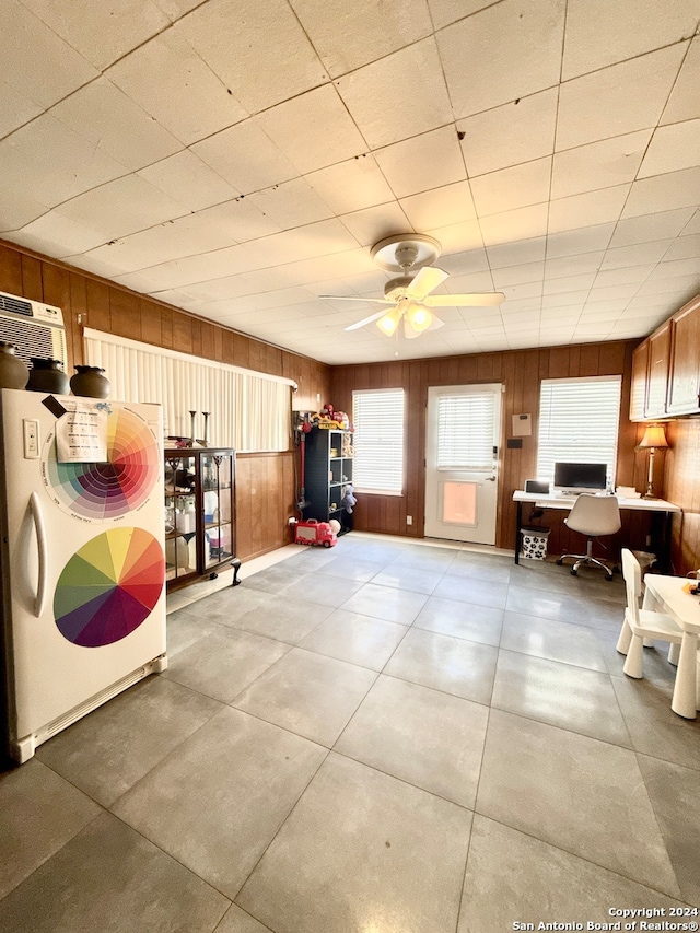 interior space featuring an AC wall unit, ceiling fan, and wood walls