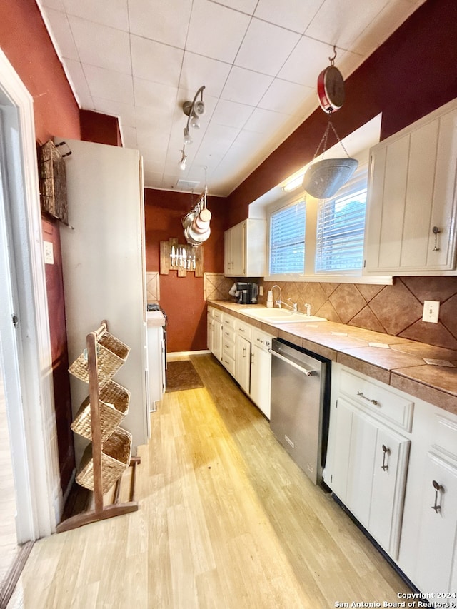 kitchen with white cabinets, pendant lighting, dishwasher, and sink