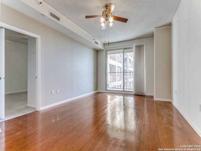 empty room with a textured ceiling, hardwood / wood-style flooring, and ceiling fan