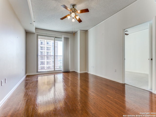 empty room featuring ceiling fan, wood-type flooring, and a textured ceiling