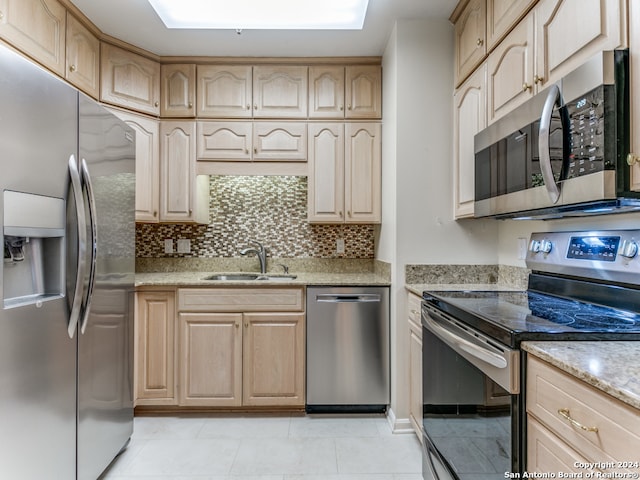 kitchen featuring appliances with stainless steel finishes, tasteful backsplash, sink, light brown cabinets, and light tile patterned floors