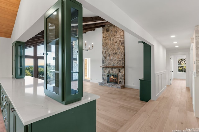 interior space with lofted ceiling with beams and green cabinets