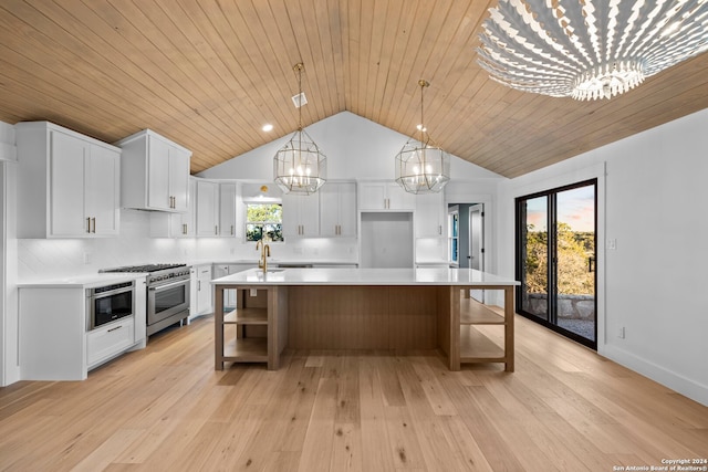 kitchen with appliances with stainless steel finishes, a center island with sink, white cabinetry, and a wealth of natural light