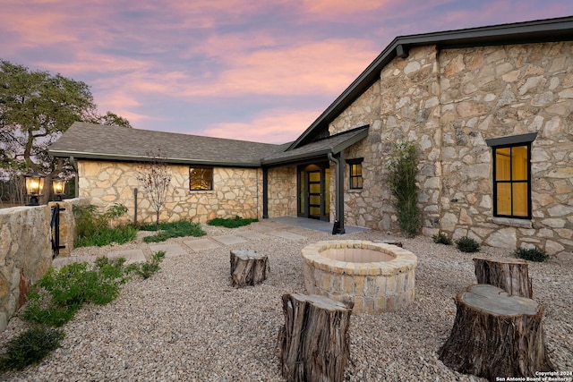 back house at dusk featuring a fire pit