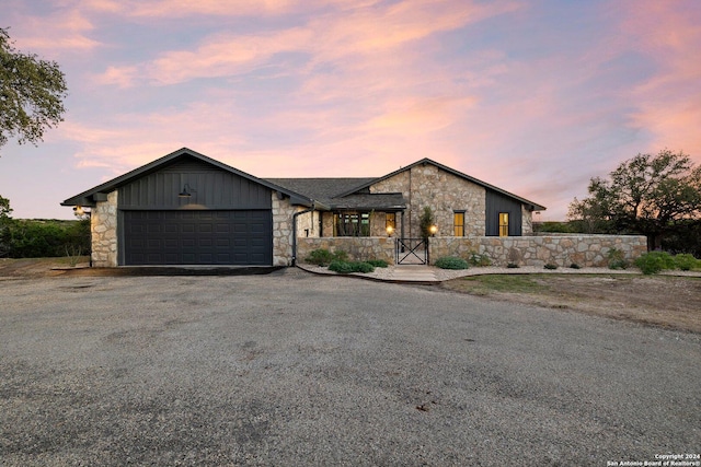 160 Mountain Way, Kerrville, TX 78028 - view of front of house with stone siding, an attached garage, asphalt driveway, and board and batten siding