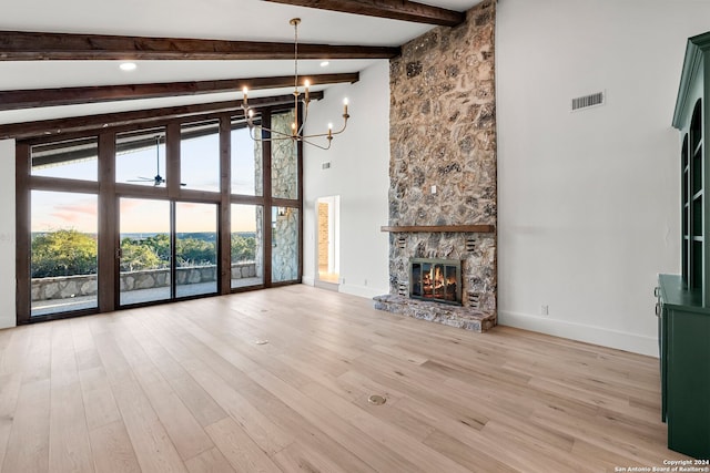 unfurnished living room featuring beam ceiling, a fireplace, an inviting chandelier, and light wood-type flooring