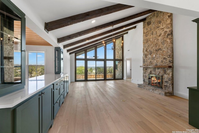 160 Mountain Way, Kerrville, TX 78028 - unfurnished living room with beam ceiling, a fireplace, light wood-type flooring, baseboards, and high vaulted ceiling