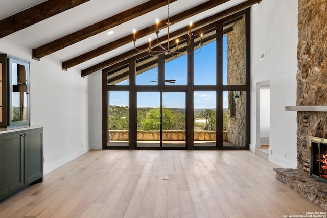 160 Mountain Way, Kerrville, TX 78028 - unfurnished living room with high vaulted ceiling, a chandelier, beam ceiling, wood finished floors, and baseboards