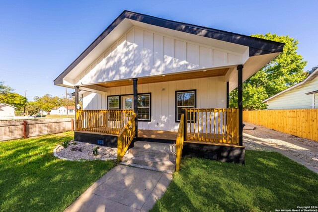 view of front of home with covered porch and a front yard