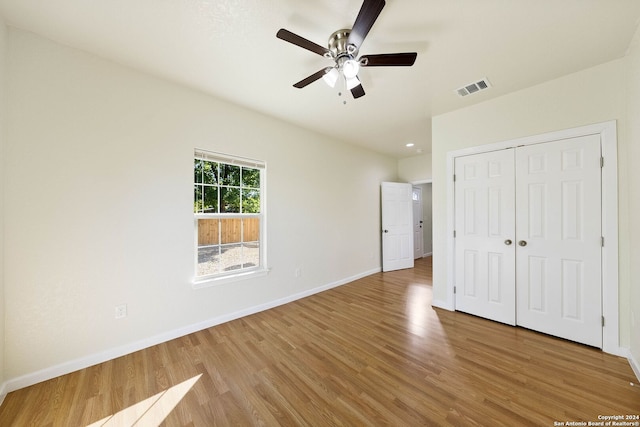 unfurnished bedroom with light wood-type flooring, a closet, and ceiling fan