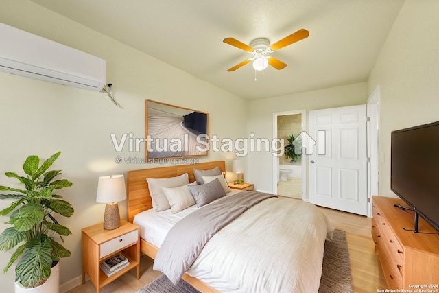 bedroom with wood-type flooring, ensuite bathroom, an AC wall unit, and ceiling fan