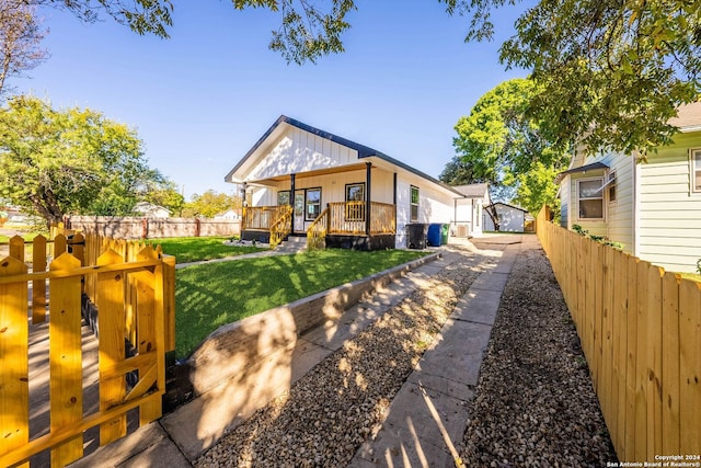 back of property with a lawn and covered porch