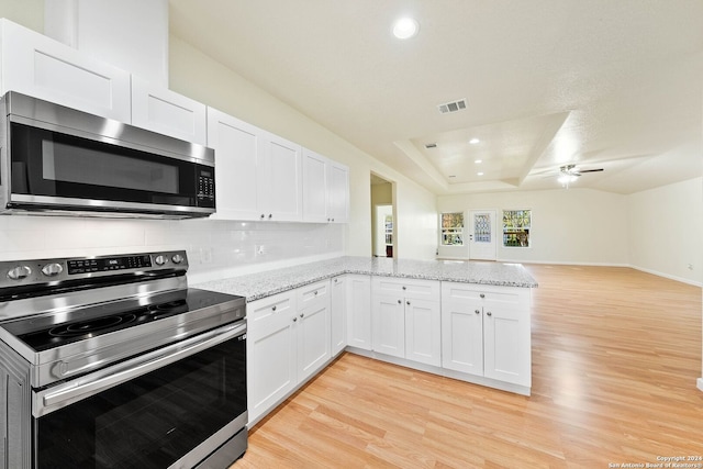 kitchen with decorative backsplash, kitchen peninsula, light wood-type flooring, stainless steel appliances, and white cabinetry