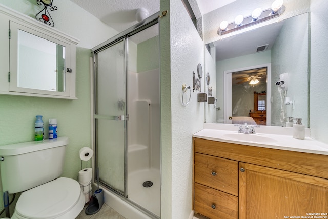 bathroom with vanity, toilet, a textured ceiling, and walk in shower