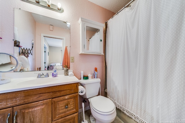 bathroom featuring a shower with curtain, vanity, toilet, and a textured ceiling