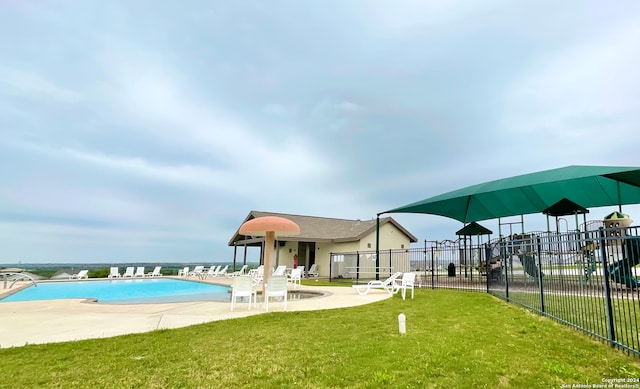 view of pool with a patio area and a yard