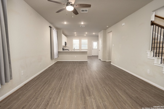 unfurnished living room with ceiling fan and dark hardwood / wood-style floors