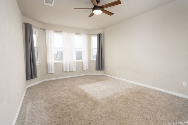 carpeted spare room with ceiling fan