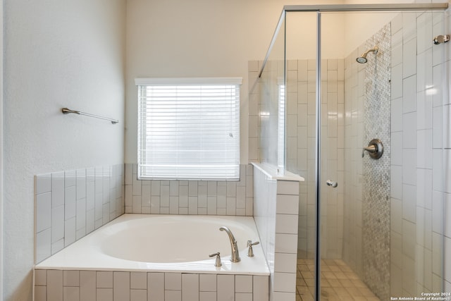 bathroom featuring shower with separate bathtub