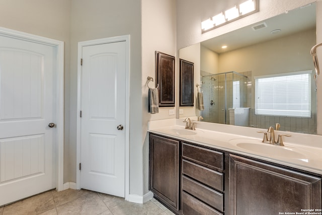 bathroom featuring tile patterned flooring, vanity, and a shower with door