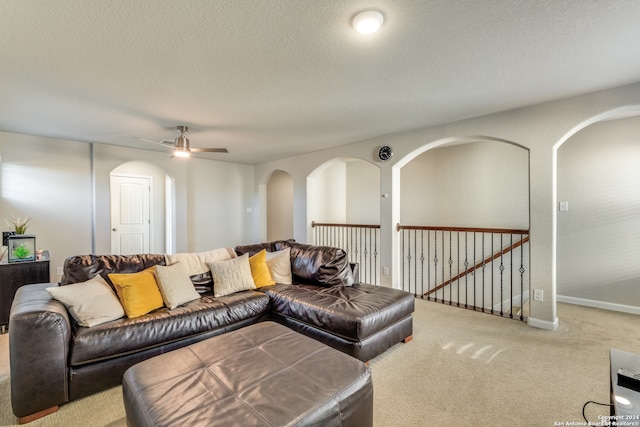 living room with carpet flooring, a textured ceiling, and ceiling fan