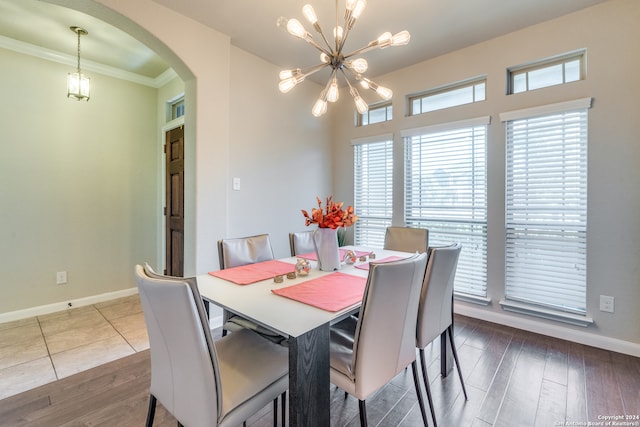 dining space with hardwood / wood-style floors, a notable chandelier, and ornamental molding