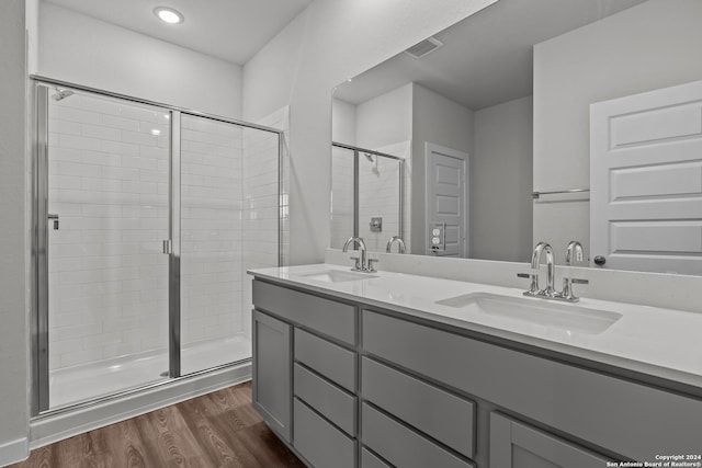 bathroom with vanity, wood-type flooring, and a shower with shower door