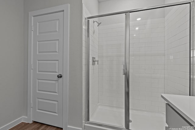 bathroom featuring wood-type flooring and a shower with shower door