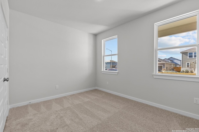 unfurnished room featuring light colored carpet