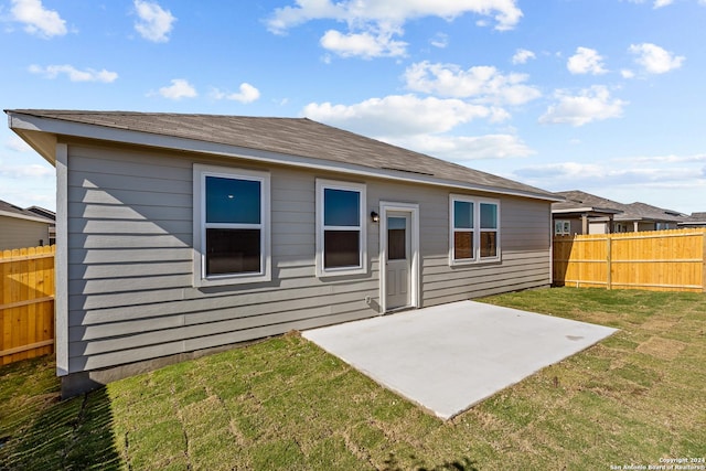 rear view of property featuring a yard and a patio