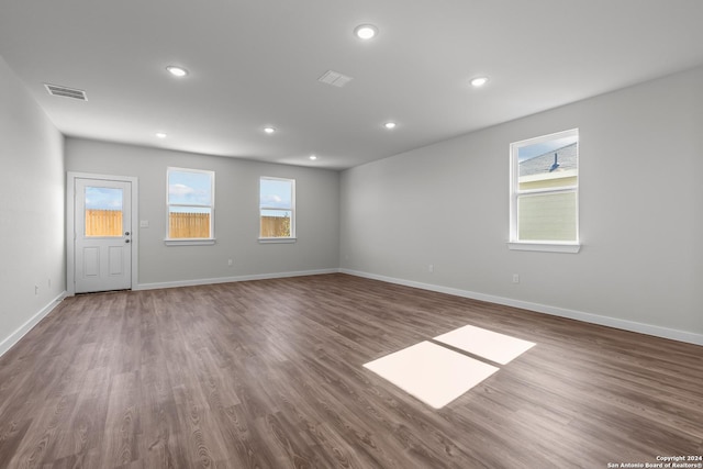 unfurnished room featuring a healthy amount of sunlight and dark wood-type flooring