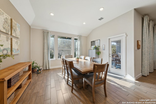 dining room with light wood-type flooring and lofted ceiling