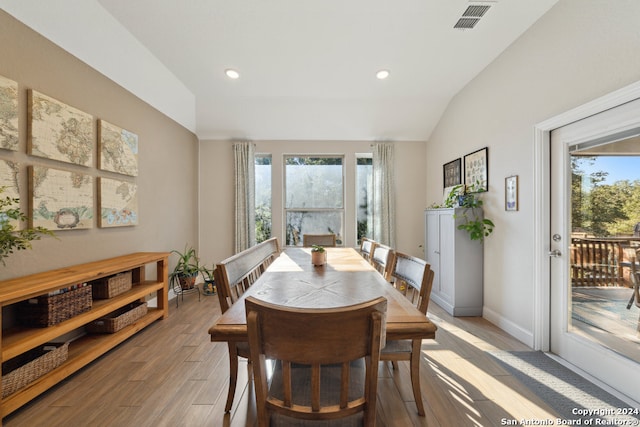 dining room featuring hardwood / wood-style floors and lofted ceiling