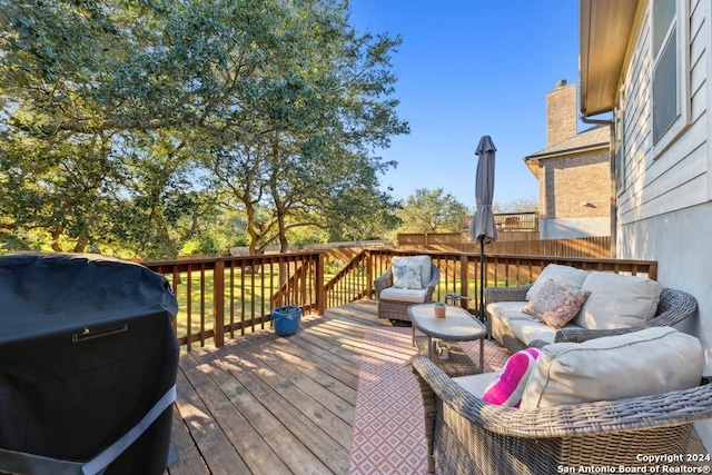 wooden terrace featuring grilling area and an outdoor living space