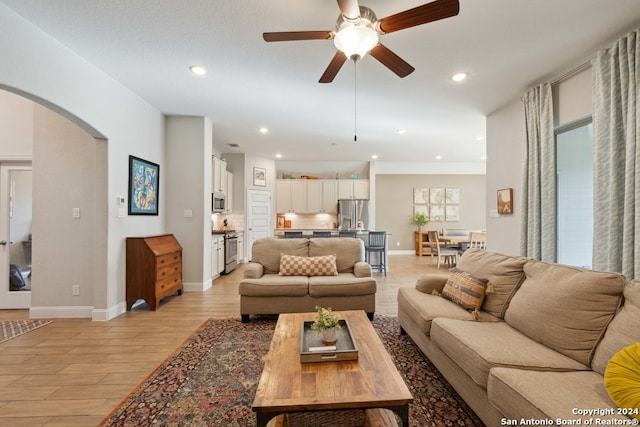 living room with ceiling fan and light hardwood / wood-style flooring