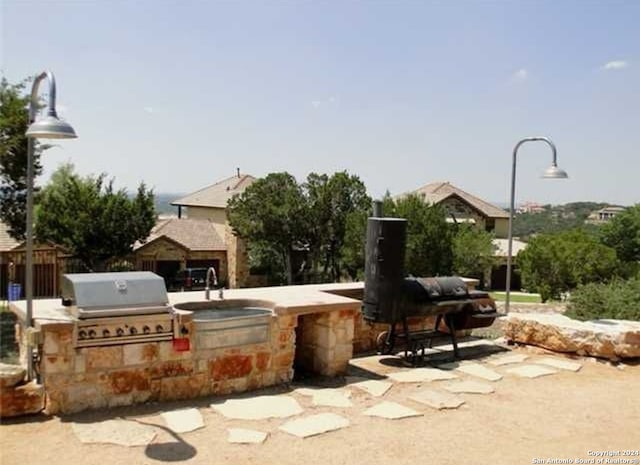 view of property's community featuring a patio area and exterior kitchen