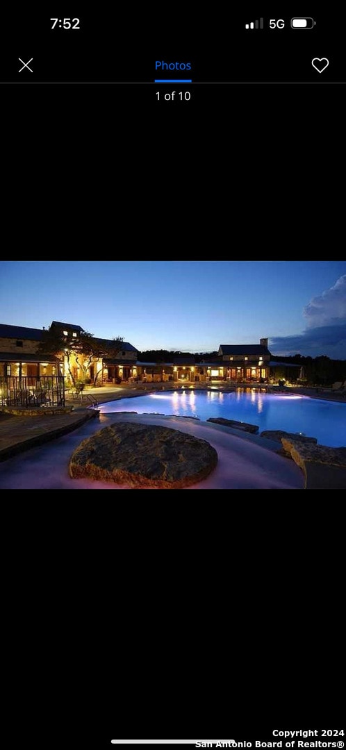 pool at dusk featuring a water view