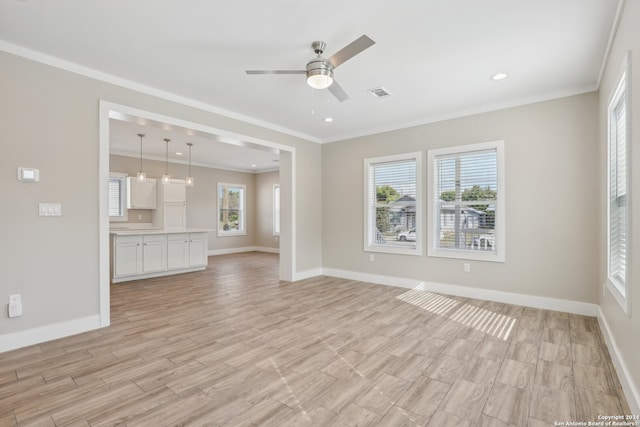 unfurnished living room featuring light hardwood / wood-style floors, ceiling fan, and crown molding