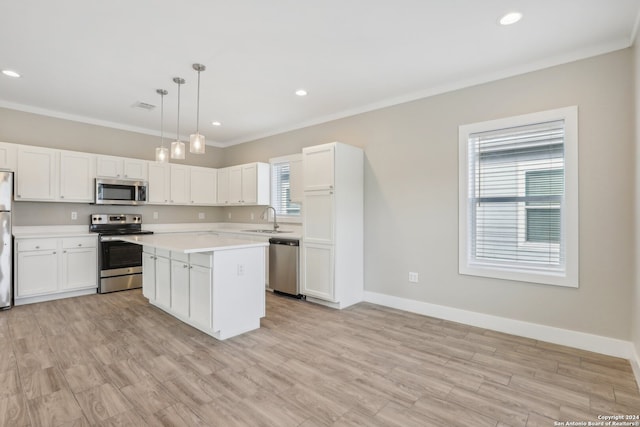 kitchen with sink, stainless steel appliances, light hardwood / wood-style floors, pendant lighting, and a kitchen island