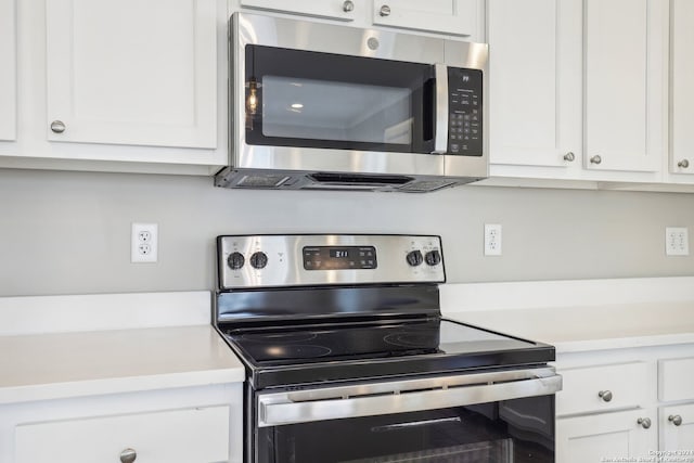 kitchen featuring stainless steel appliances and white cabinetry