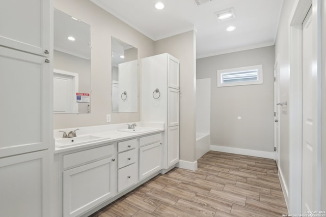 bathroom with a bathtub, vanity, and wood-type flooring